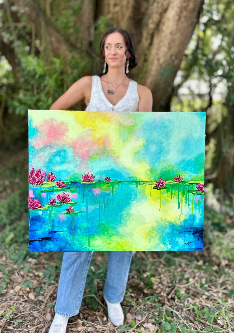 carli danae holding her water lily painting outdoors